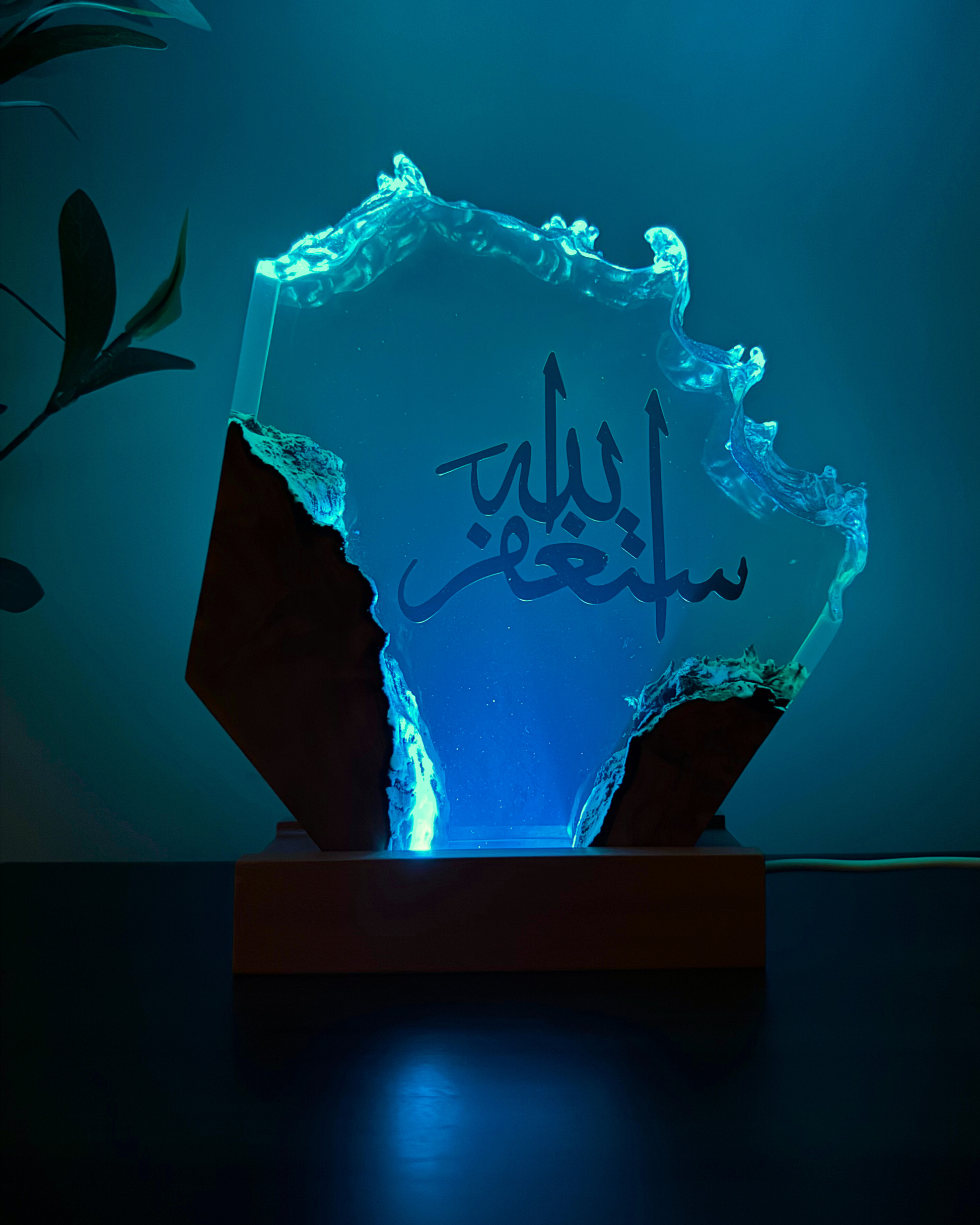 Handcrafted olive wood and resin Islamic décor glowing under LED light in a dark room