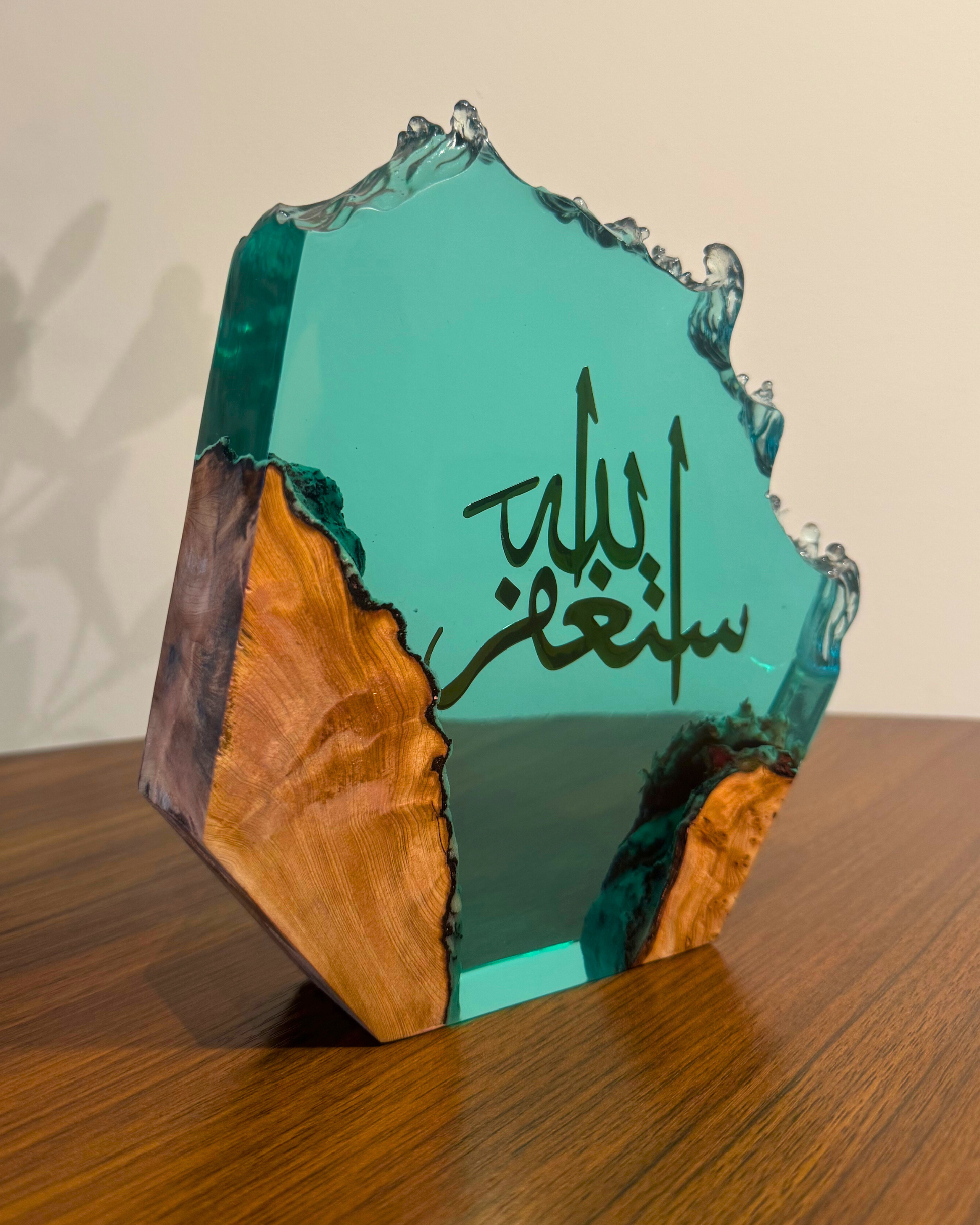 Light blue resin and olive wood sculpture with Arabic calligraphy.