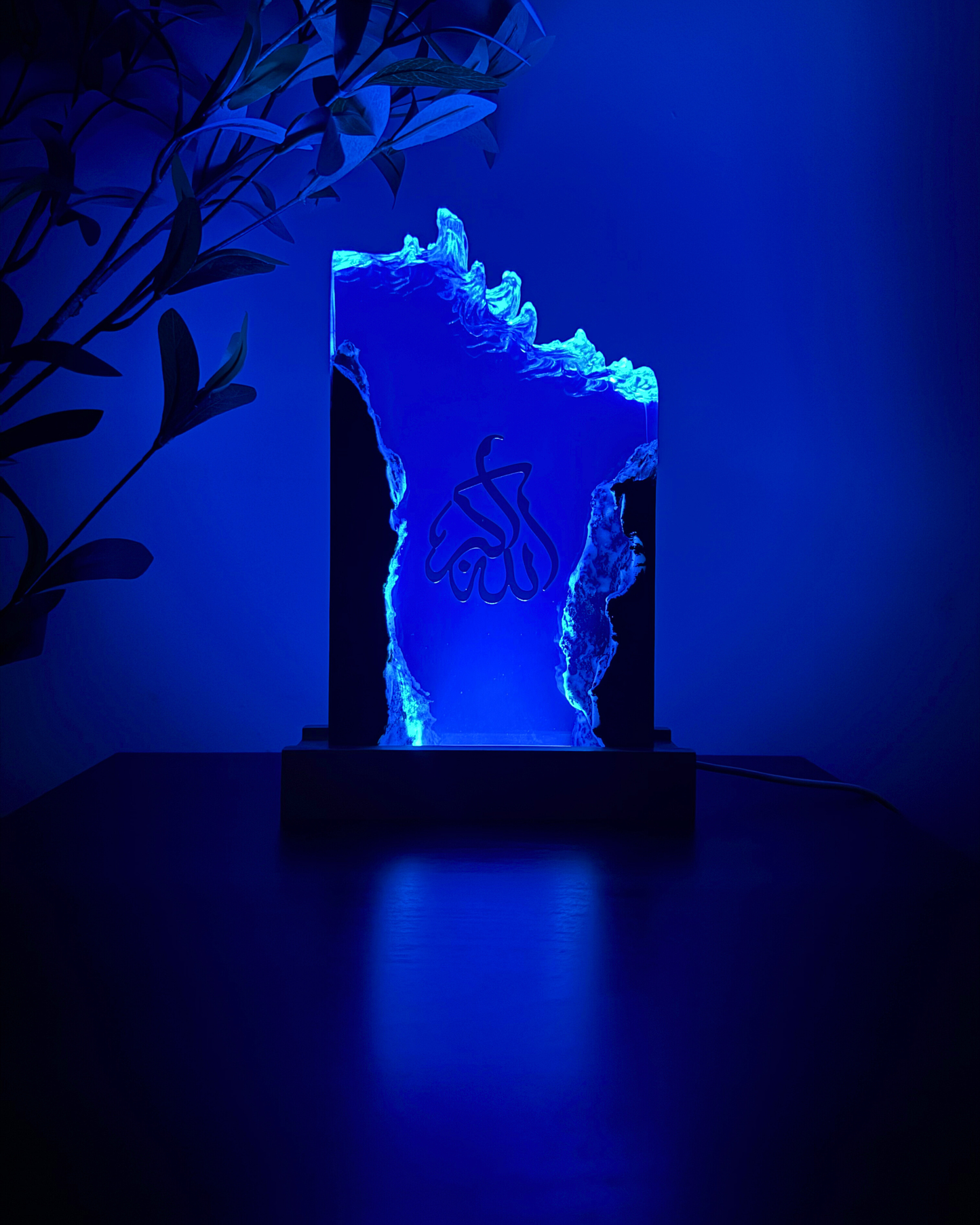 One-of-a-kind wood resin art piece illuminated at night, showing gold Arabic calligraphy.